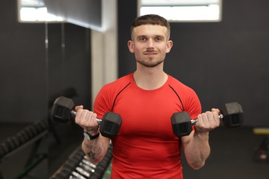 Photo of Professional personal trainer with dumbbells in gym
