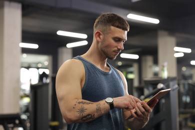 Photo of Personal trainer with tablet in sport center