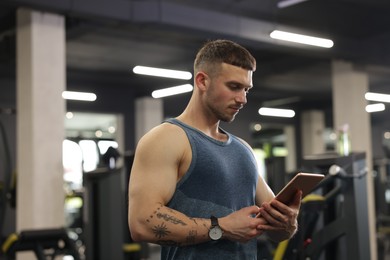 Photo of Personal trainer with tablet in sport center