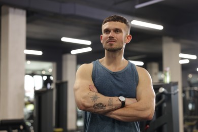 Photo of Portrait of professional personal trainer in gym. Space for text