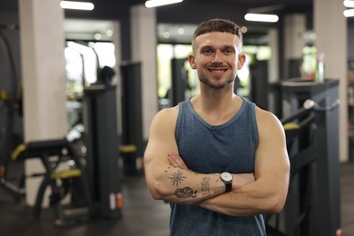 Photo of Portrait of professional personal trainer in gym. Space for text