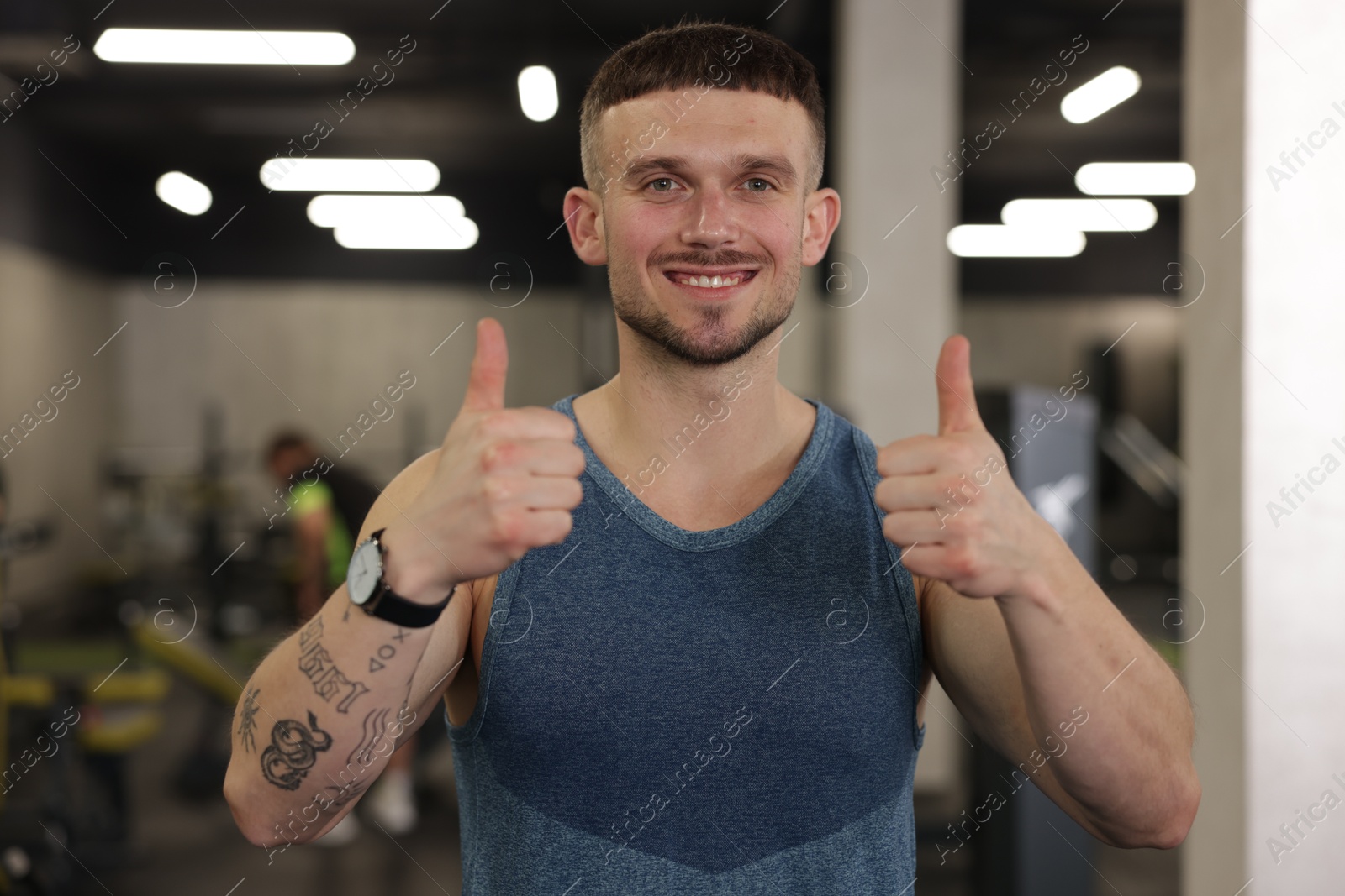 Personal trainer showing thumbs ups in gym Photo of Personal trainer showing thumbs ups in gym