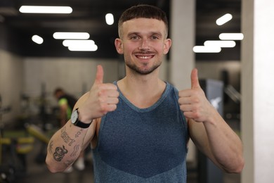 Photo of Personal trainer showing thumbs ups in gym