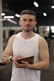 Photo of Personal trainer with tablet in sport center