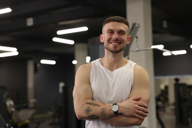 Photo of Portrait of professional personal trainer in gym. Space for text