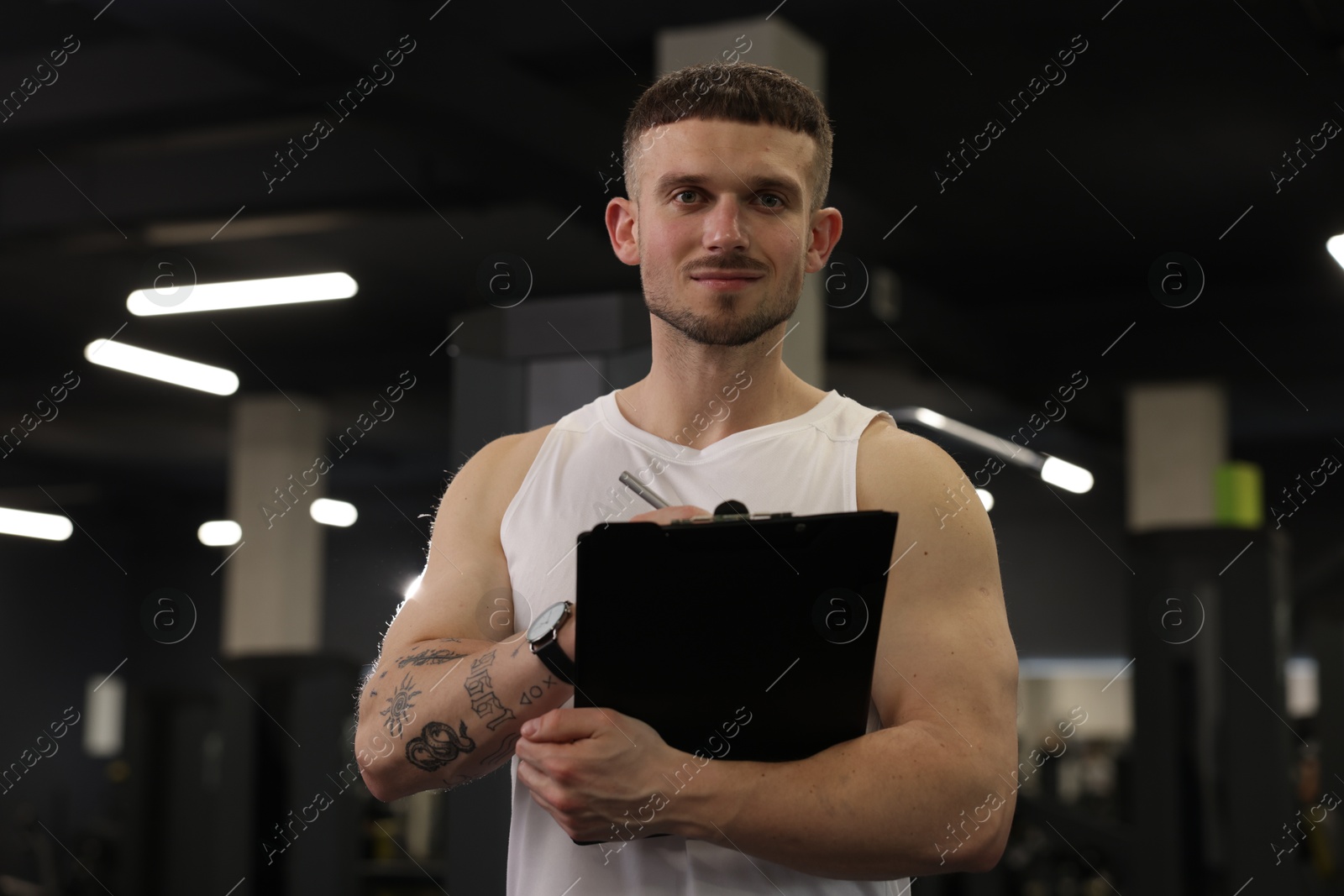 Personal trainer with clipboard in sport center Photo of Personal trainer with clipboard in sport center