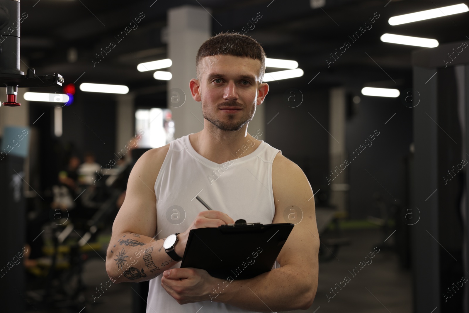 Personal trainer with clipboard in sport center Photo of Personal trainer with clipboard in sport center