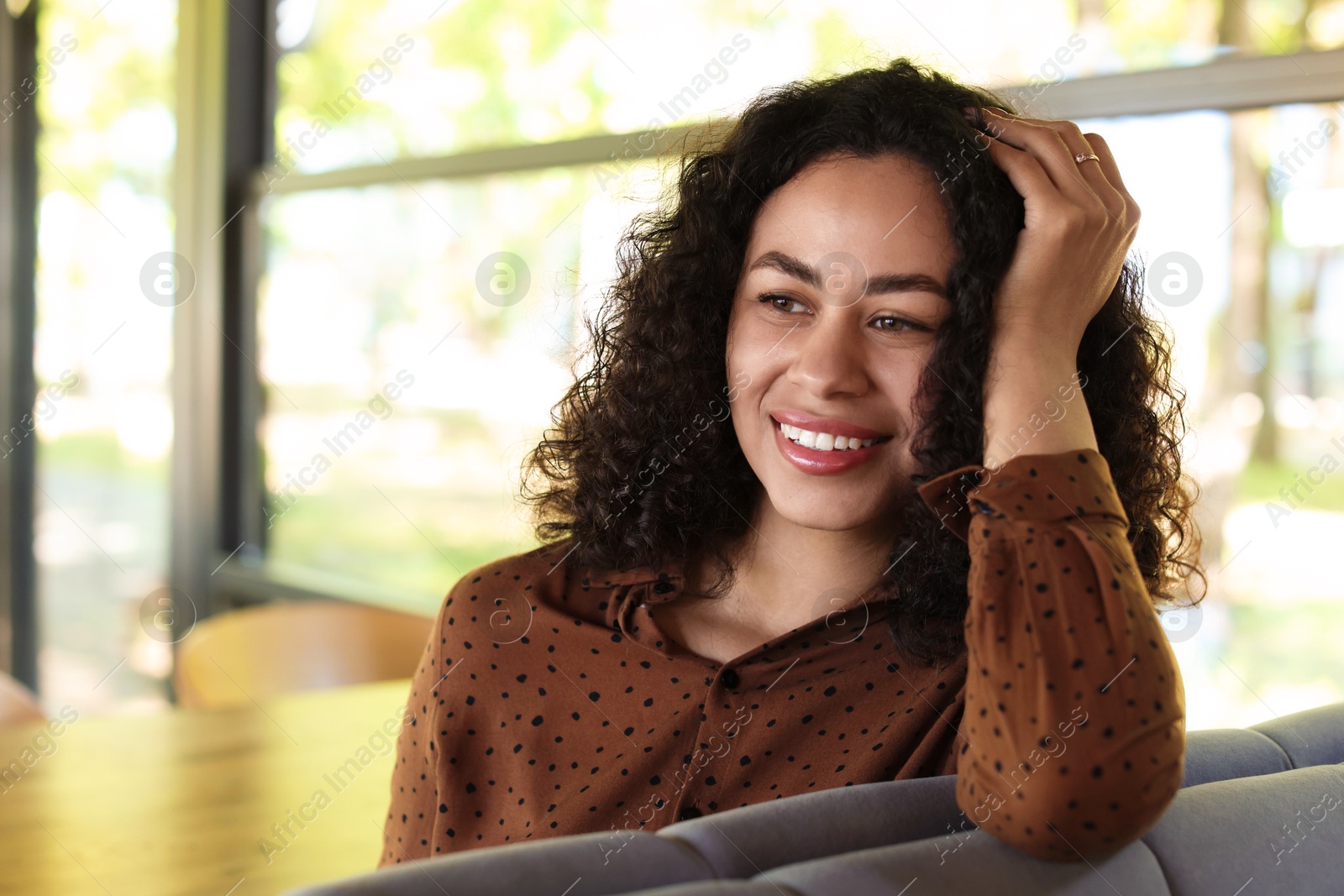 Portrait of smiling Latin American woman in cafe Photo of Portrait of smiling Latin American woman in cafe