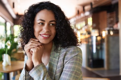 Photo of Portrait of smiling Latin American woman in cafe