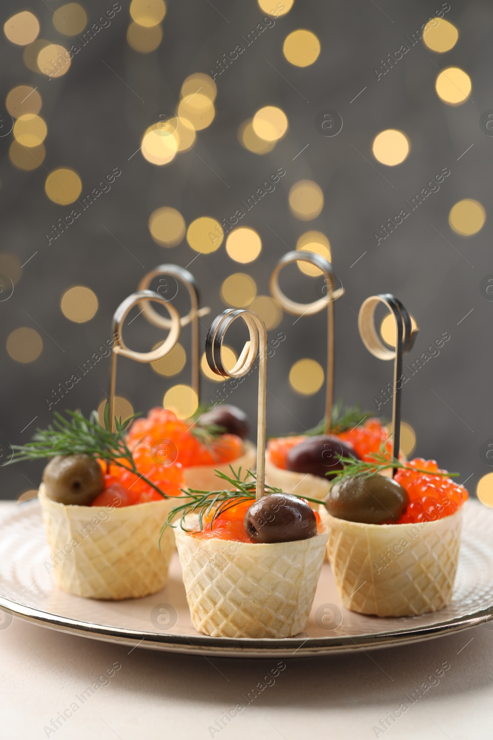 Photo of Tasty canapes on white table against blurred lights, closeup