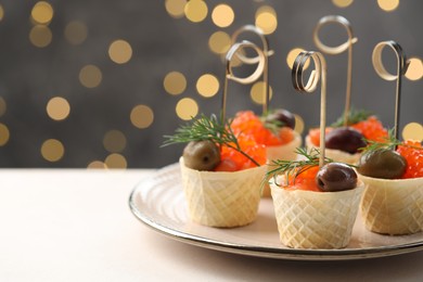 Photo of Tasty canapes on white table against blurred lights, closeup. Space for text