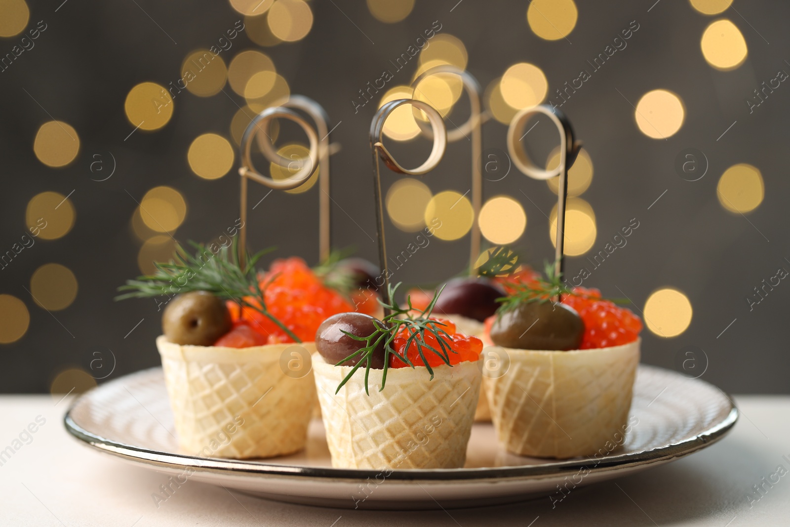 Photo of Tasty canapes on white table against blurred lights, closeup