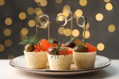 Photo of Tasty canapes on white table against blurred lights, closeup