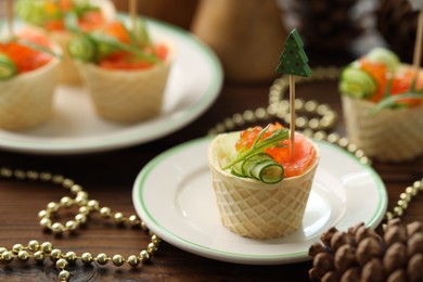 Photo of Tasty canapes and festive decor on wooden table, closeup