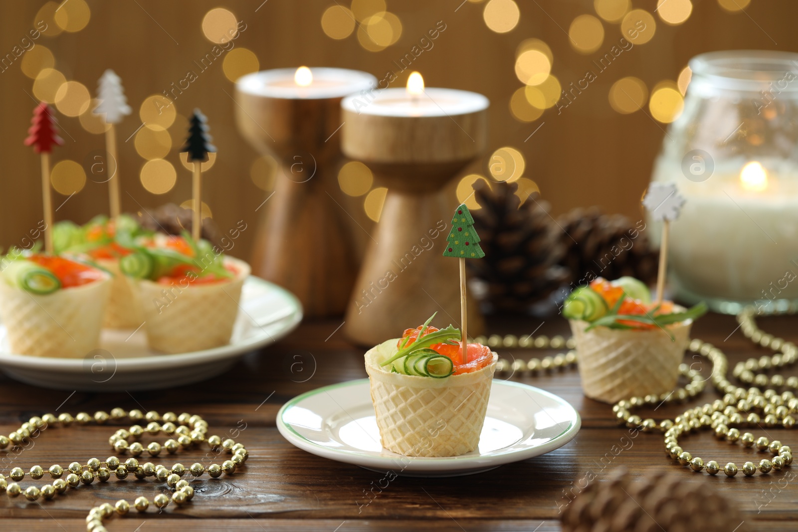 Photo of Tasty canapes and festive decor on wooden table against blurred lights, closeup. Bokeh effect
