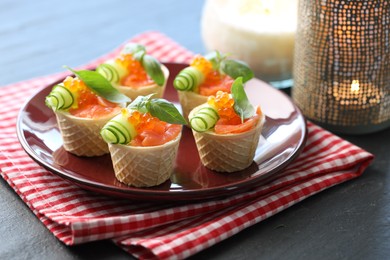 Photo of Tasty canapes with salmon on blue wooden table, closeup