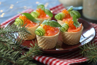 Photo of Tasty canapes and fir tree branches on table, closeup