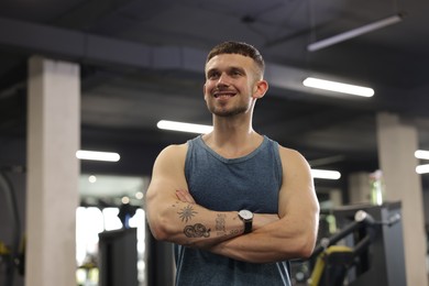Photo of Portrait of professional personal trainer in gym. Space for text