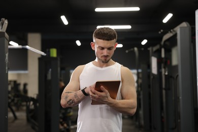 Photo of Personal trainer with tablet in sport center