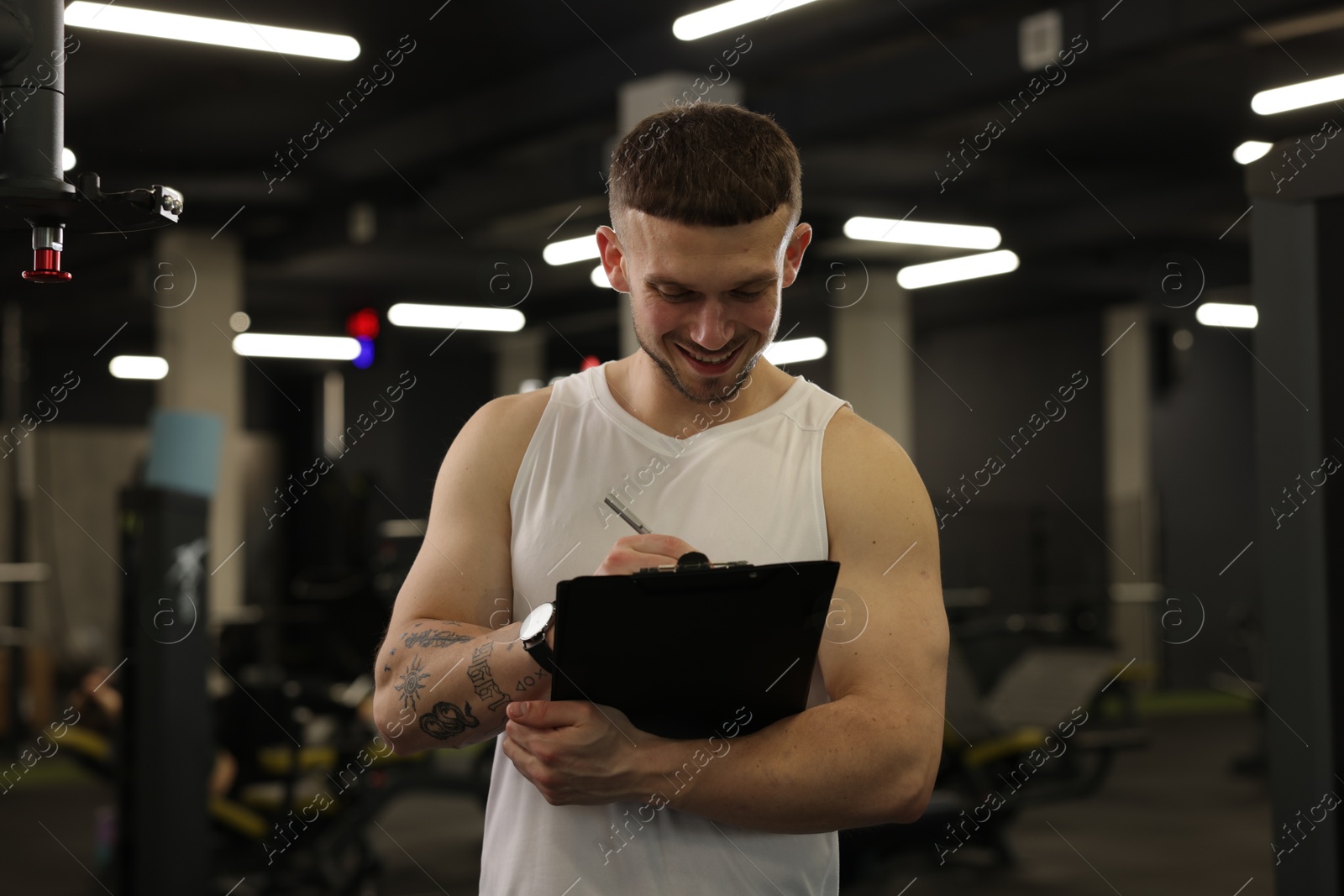 Personal trainer with clipboard in sport center Photo of Personal trainer with clipboard in sport center