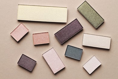 Photo of Beautiful eyeshadow refill pans on beige background, flat lay