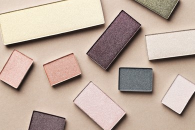 Photo of Beautiful eyeshadow refill pans on beige background, flat lay