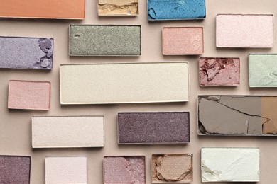 Photo of Beautiful eyeshadow refill pans on beige background, flat lay
