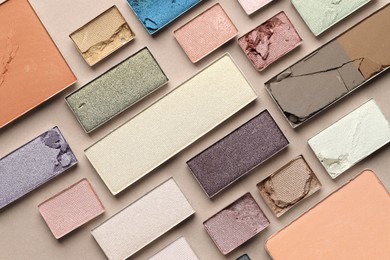 Photo of Beautiful eyeshadow refill pans on beige background, flat lay