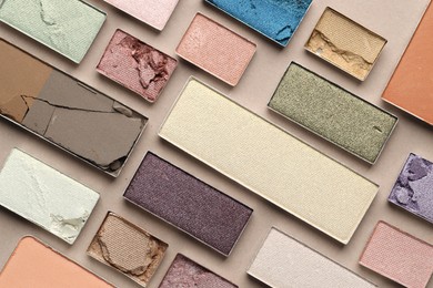 Photo of Beautiful eyeshadow refill pans on beige background, flat lay