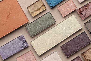 Photo of Beautiful eyeshadow refill pans on beige background, flat lay