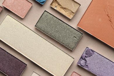 Photo of Beautiful eyeshadow refill pans on beige background, flat lay