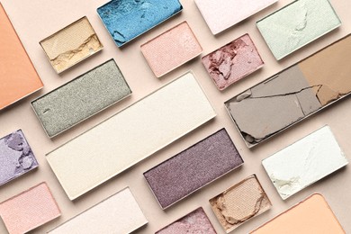 Photo of Beautiful eyeshadow refill pans on beige background, flat lay