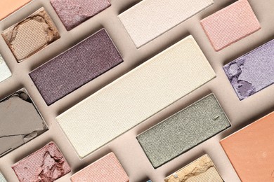 Photo of Beautiful eyeshadow refill pans on beige background, flat lay