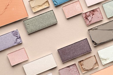 Photo of Beautiful eyeshadow refill pans on beige background, flat lay
