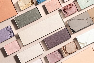 Photo of Beautiful eyeshadow refill pans on beige background, flat lay