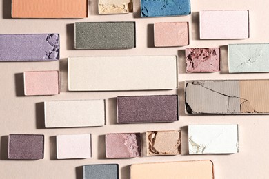 Photo of Beautiful eyeshadow refill pans on beige background, flat lay