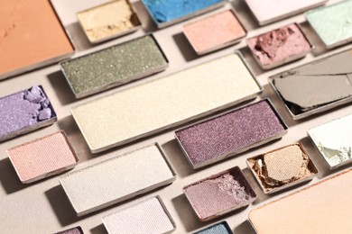 Photo of Beautiful eyeshadow refill pans on beige background, closeup