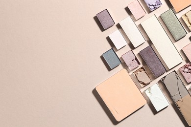 Photo of Beautiful eyeshadow refill pans on beige background, flat lay. Space for text