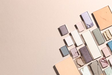 Photo of Beautiful eyeshadow refill pans on beige background, flat lay. Space for text