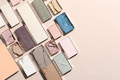 Photo of Beautiful eyeshadow refill pans on beige background, flat lay. Space for text