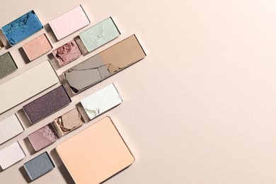 Photo of Beautiful eyeshadow refill pans on beige background, flat lay. Space for text