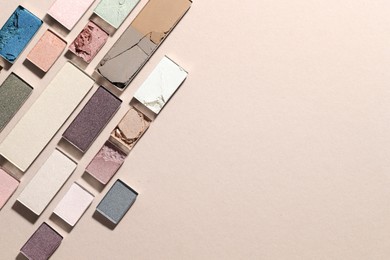Photo of Beautiful eyeshadow refill pans on beige background, flat lay. Space for text