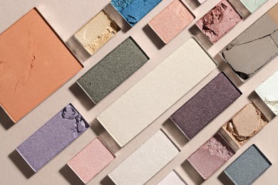 Photo of Beautiful eyeshadow refill pans on beige background, flat lay