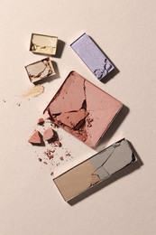 Photo of Beautiful eyeshadow refill pans on beige background, flat lay