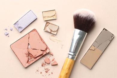 Photo of Beautiful eyeshadow refill pans and brush on beige background, flat lay