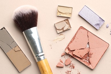 Photo of Beautiful eyeshadow refill pans and brush on beige background, flat lay