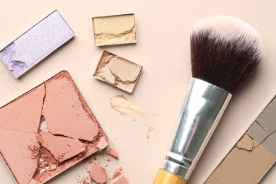 Photo of Beautiful eyeshadow refill pans and brush on beige background, flat lay