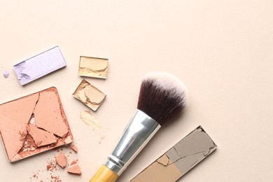 Photo of Beautiful eyeshadow refill pans and brush on beige background, flat lay. Space for text