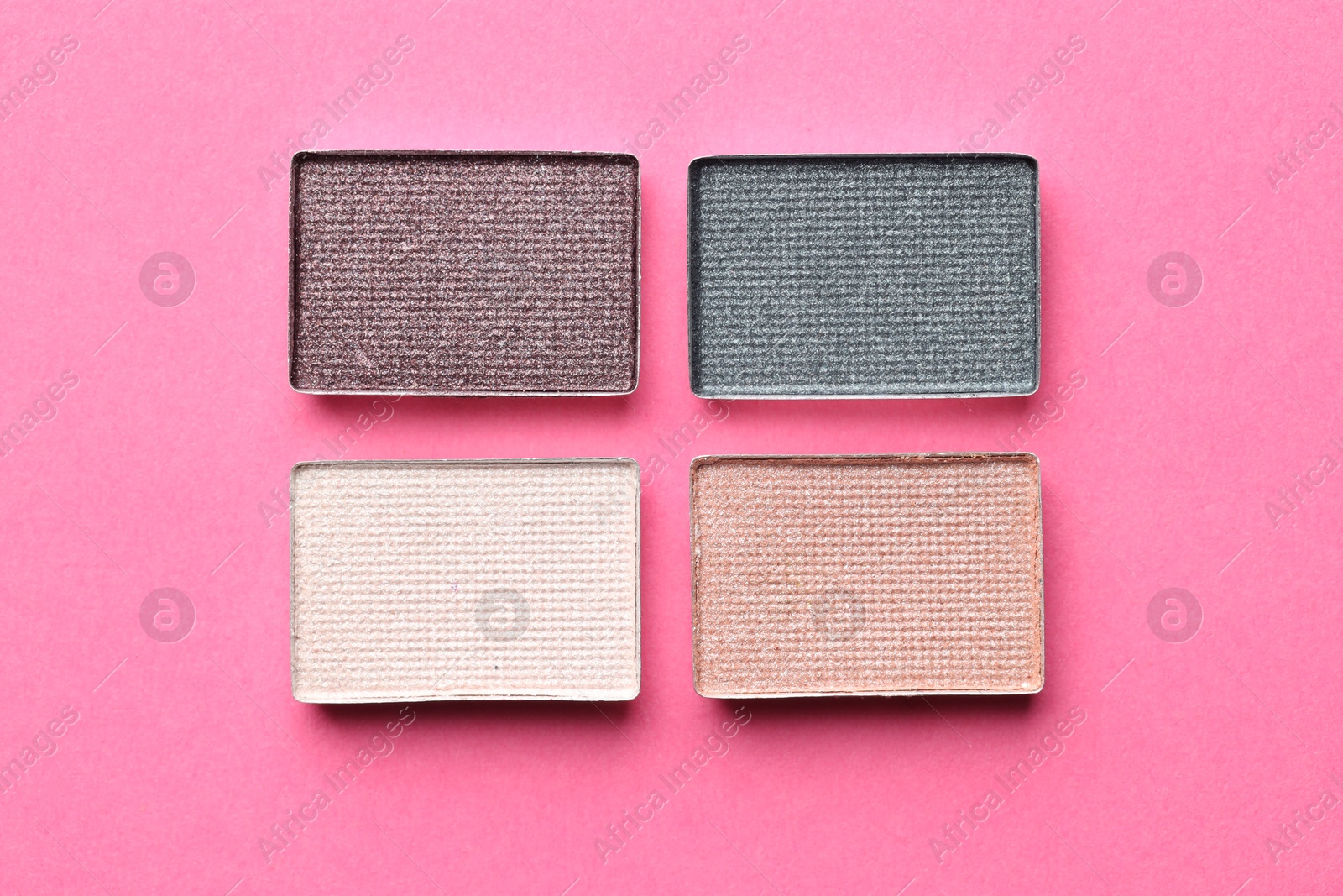 Beautiful eyeshadow refill pans on pink background, flat lay Photo of Beautiful eyeshadow refill pans on pink background, flat lay