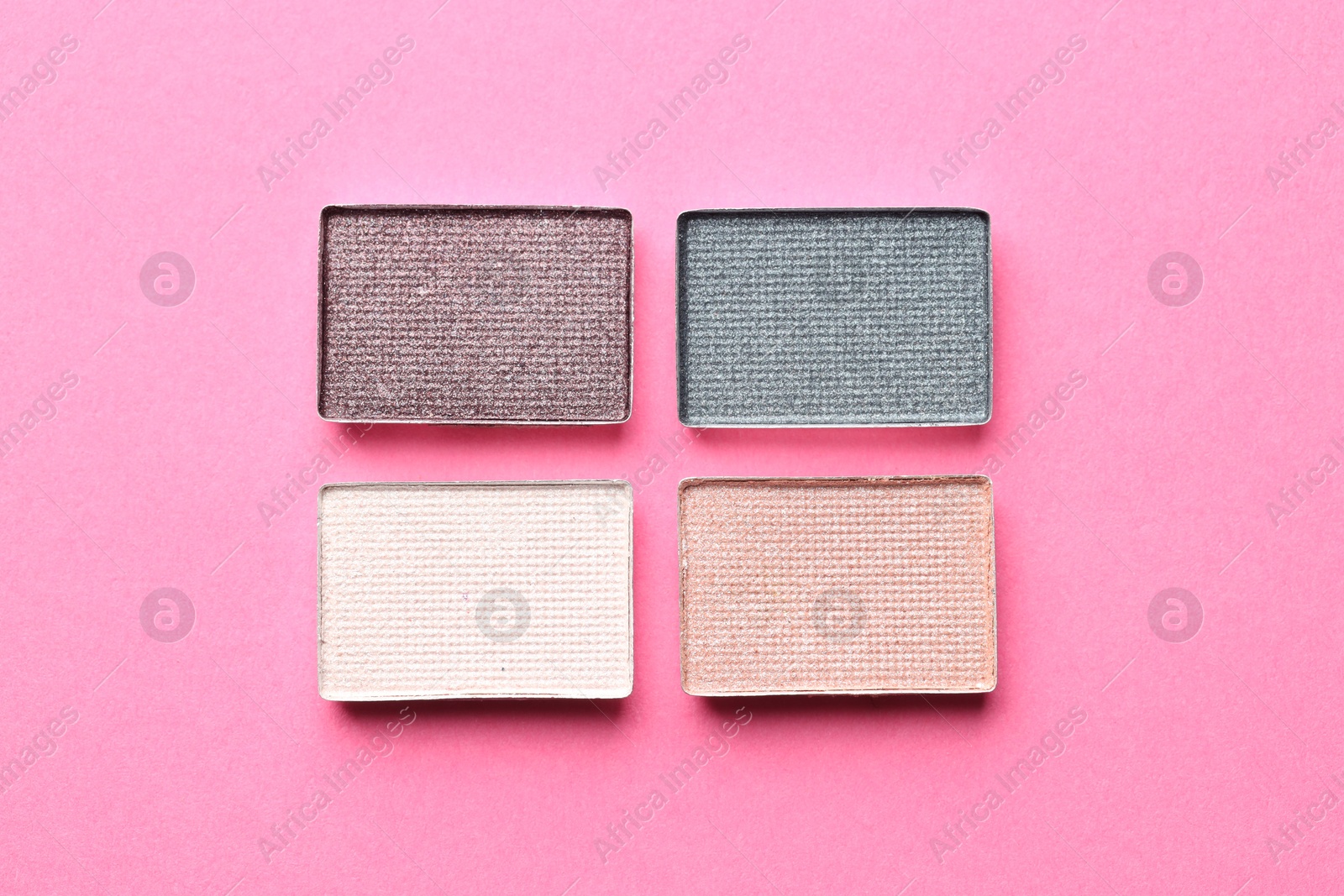 Beautiful eyeshadow refill pans on pink background, flat lay Photo of Beautiful eyeshadow refill pans on pink background, flat lay